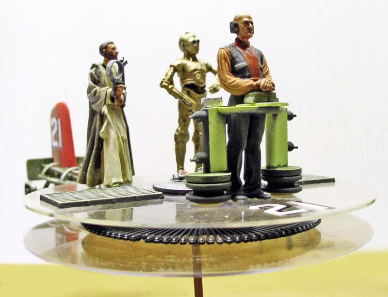Figurines peintes d'Obi-Wan Kenobi, C-3PO et personnage devant une console verte sur socle
