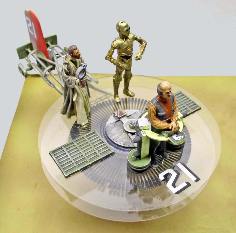 Diorama Star Wars avec figurines Obi-Wan Kenobi, C-3PO doré et personnage assis sur socle transparent numéroté 21