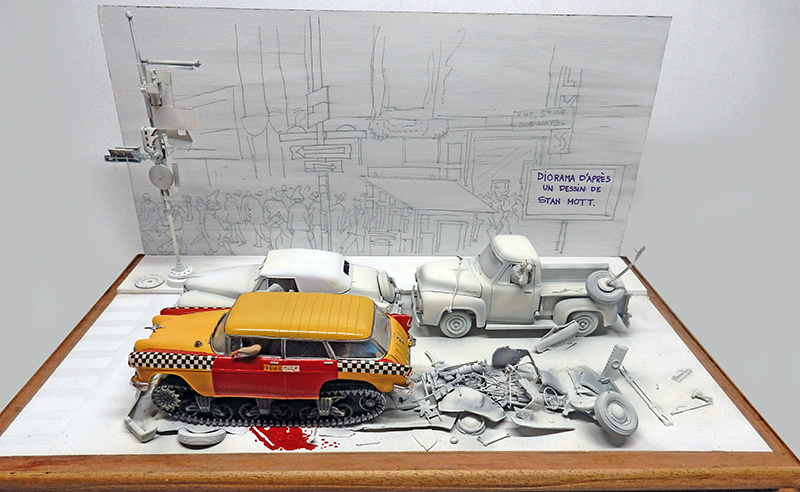 Diorama de maquettes représentant un taxi jaune à chenilles écrasant des voitures grises sur une rue