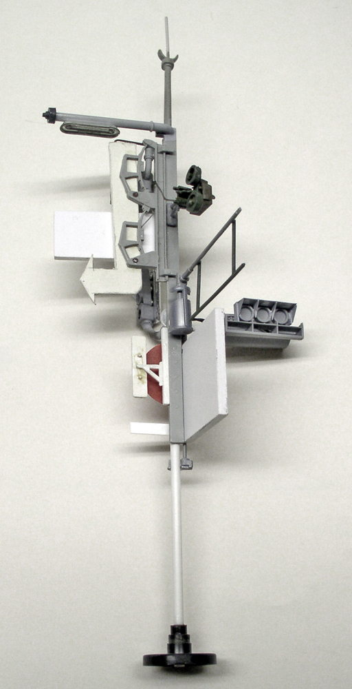 Maquette grise de superstructure de navire avec mât, radar et passerelle en cours d'assemblage