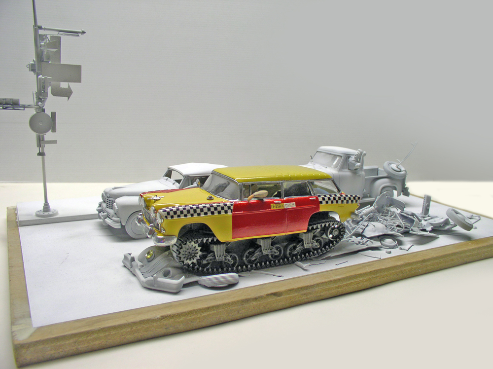 Maquette de taxi américain jaune et rouge sur chenilles parmi des épaves grises