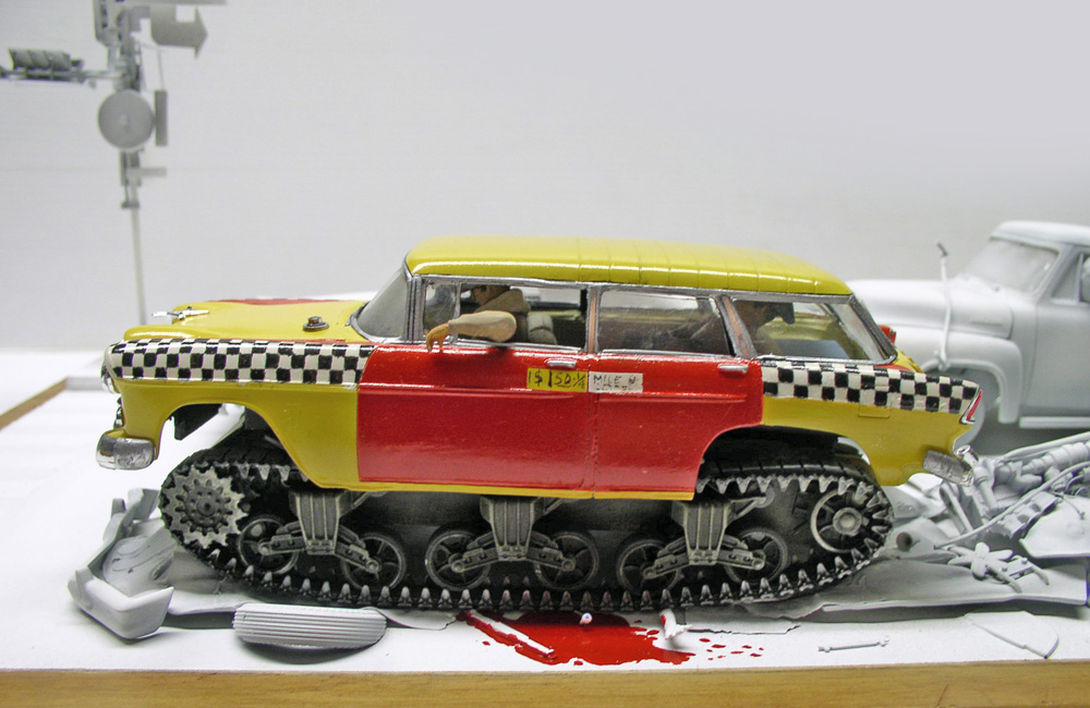 Maquette de taxi américain jaune et rouge monté sur chenilles écrasant des figurines ensanglantées