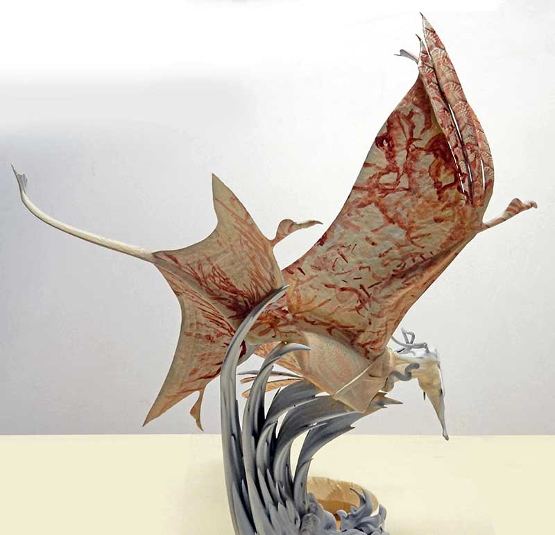 Maquette de créature ailée type banshee d'Avatar 2 aux ailes membraneuses rouges sur socle gris