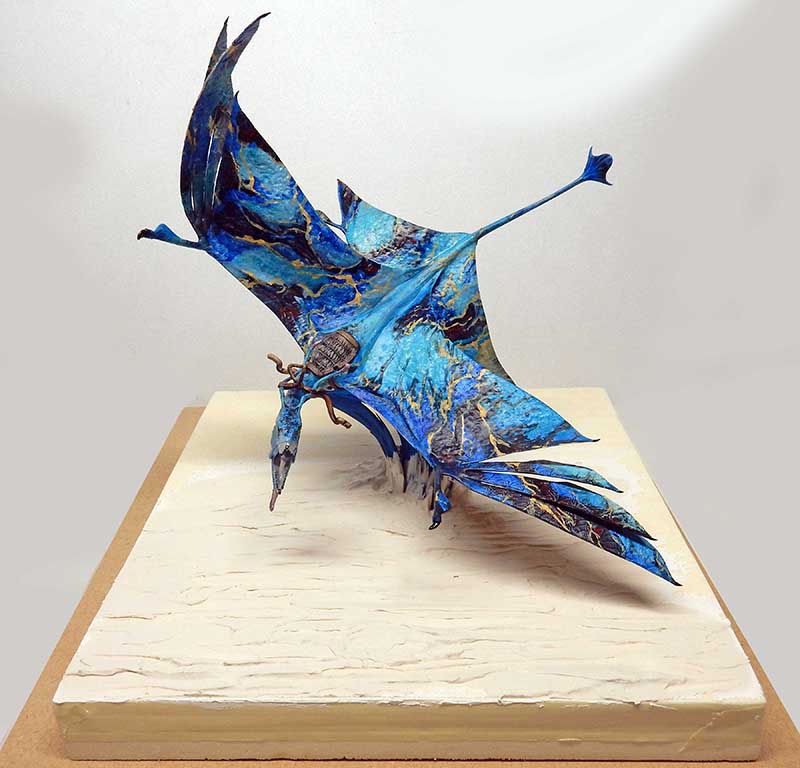 Maquette d'une créature volante bleue ailée d'Avatar 2 posée sur un socle clair
