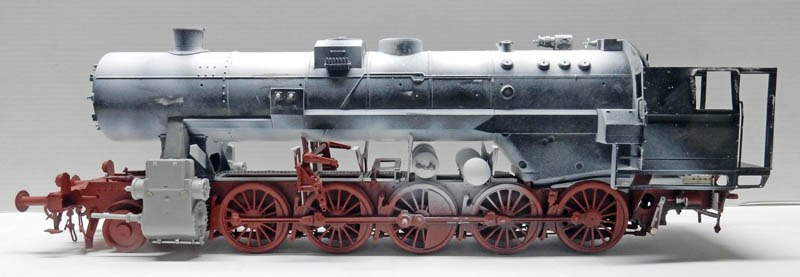 Maquette de locomotive à vapeur BR52 en cours de peinture, châssis rouge et chaudière grise