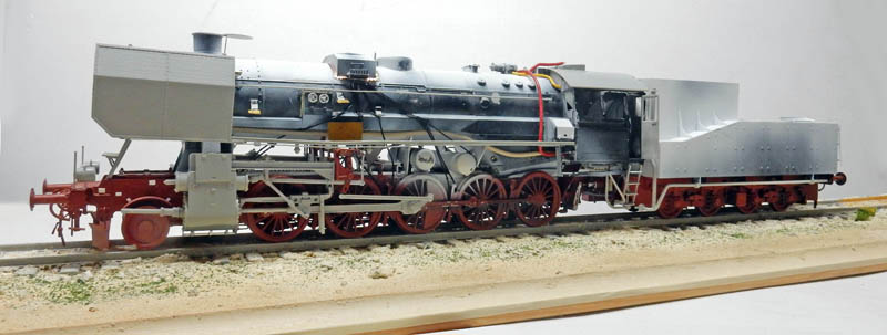 Maquette de locomotive à vapeur BR52 gris et rouge avec tender sur voie