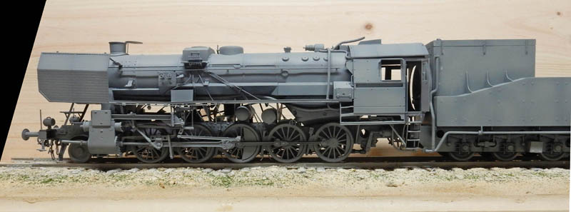 Maquette grise de locomotive à vapeur BR52 vue de profil sur voie ferrée miniature