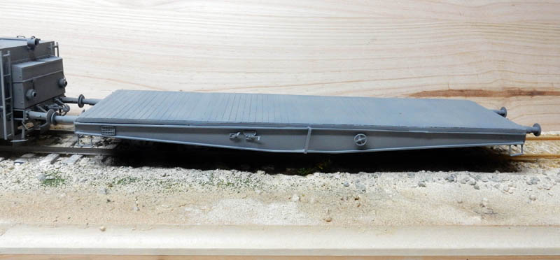 Maquette grise du tender plat de la locomotive BR52 posée sur une voie ferrée