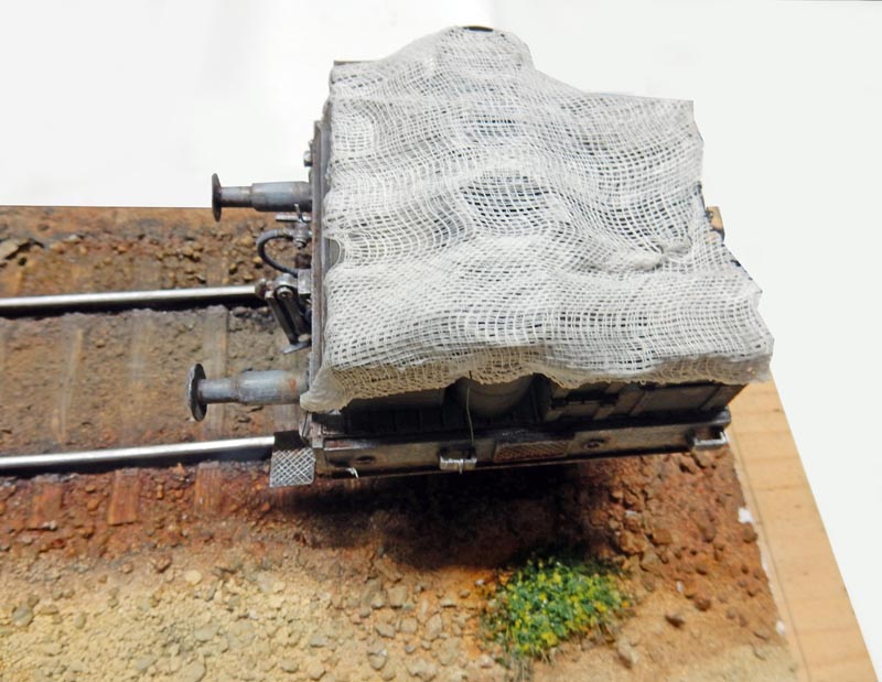 Maquette de locomotive BR52 recouverte de gaze blanche sur diorama de voie ferrée