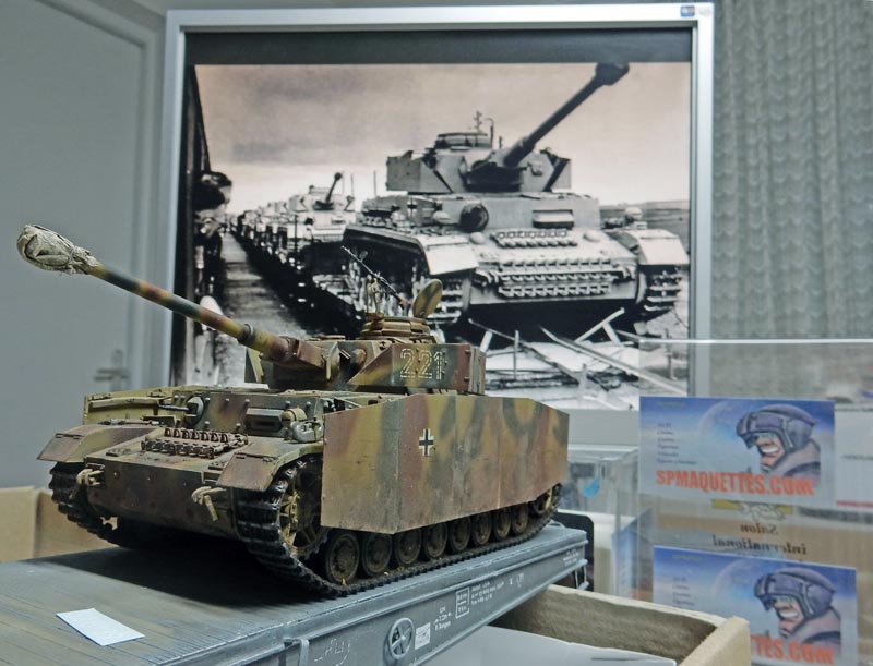 Maquette de char allemand Panzer IV numéro 224 en camouflage devant une photo historique de chars