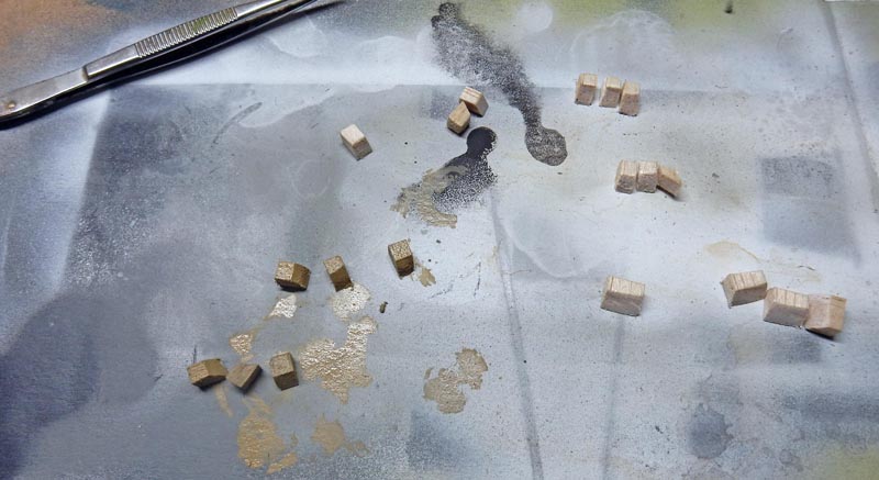 Petits blocs de bois découpés et pince à épiler sur surface de travail pour maquette BR52