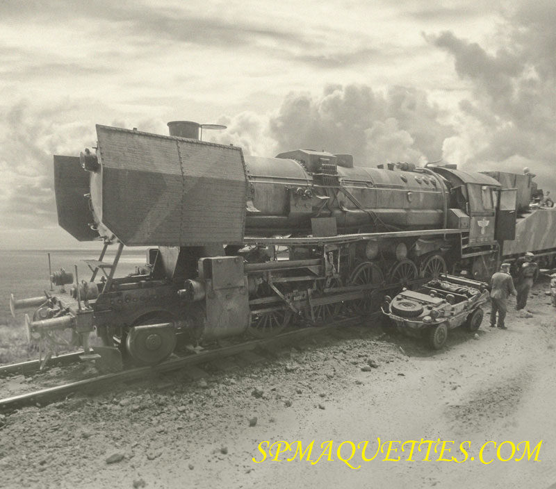 Locomotive à vapeur BR52 vue de profil avec soldats et véhicule amphibie sur voie ferrée