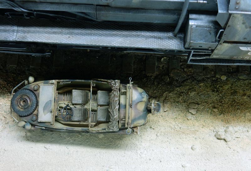 Maquette d'un véhicule militaire vue de dessus près d'une locomotive BR52 sur diorama
