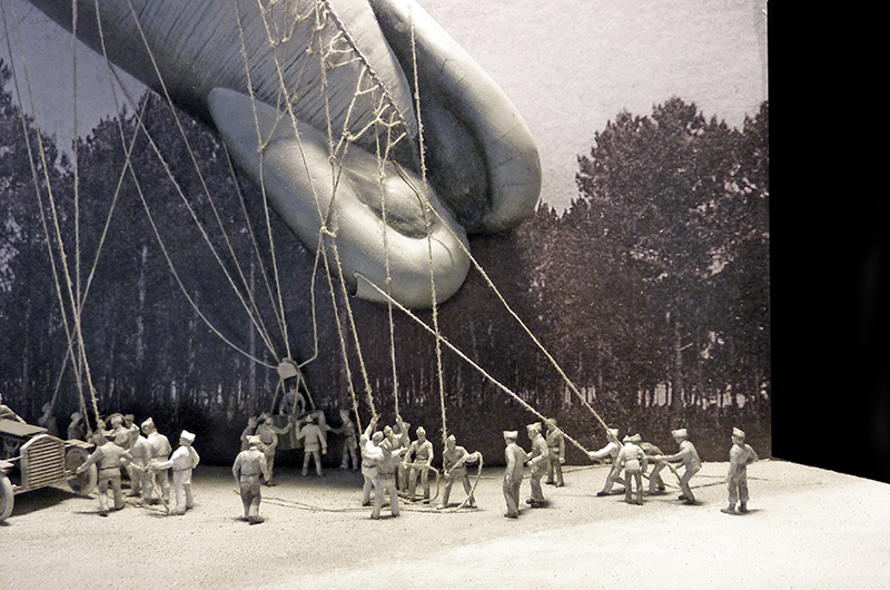 Maquette de soldats retenant aux cordages un ballon d'observation 1917 devant des arbres