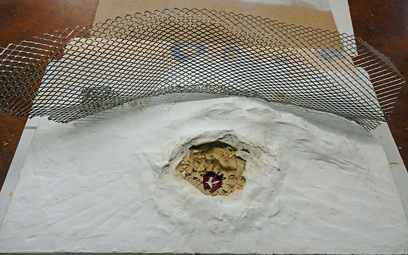 Maquette de cratère en plâtre blanc avec grille métallique déployée et décor central peint