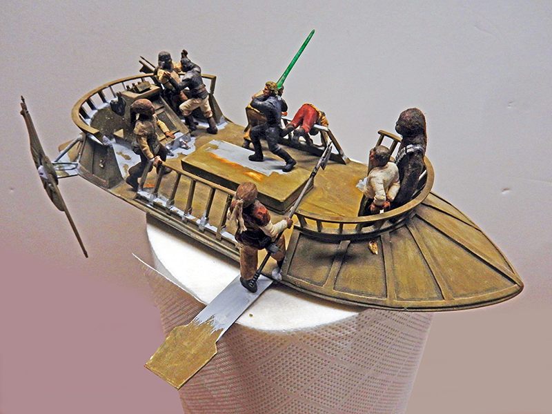Maquette de barge volante Star Wars avec figurines peintes et personnage brandissant un sabre laser vert