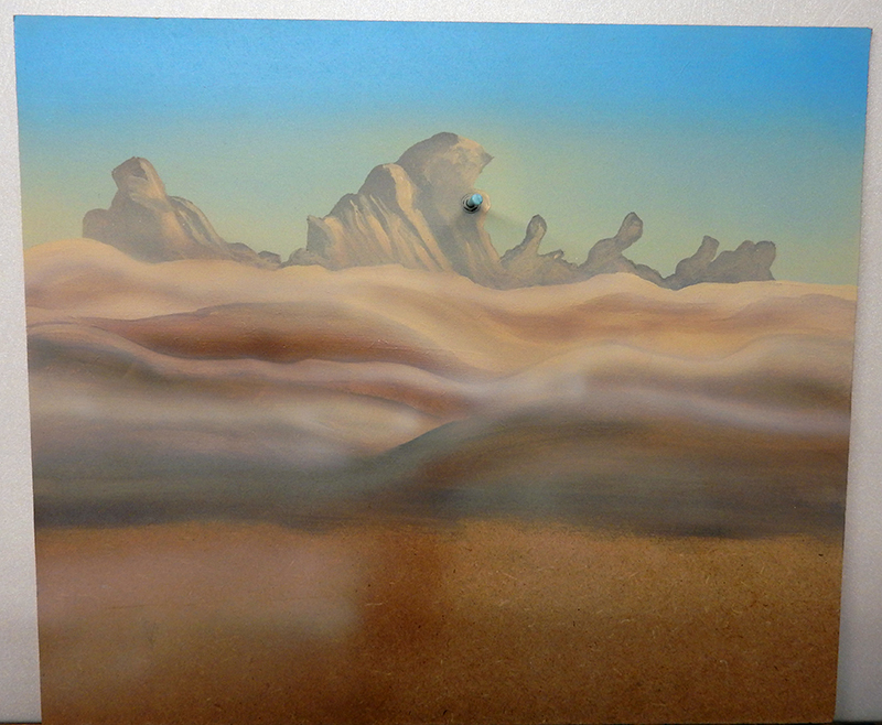 Décor de fond peint à l'aérographe représentant un paysage désertique avec dunes et rochers sous ciel bleu