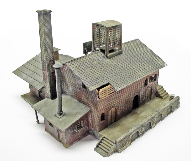 Maquette d'un bâtiment industriel en briques avec cheminées, château d'eau et toiture en tuiles