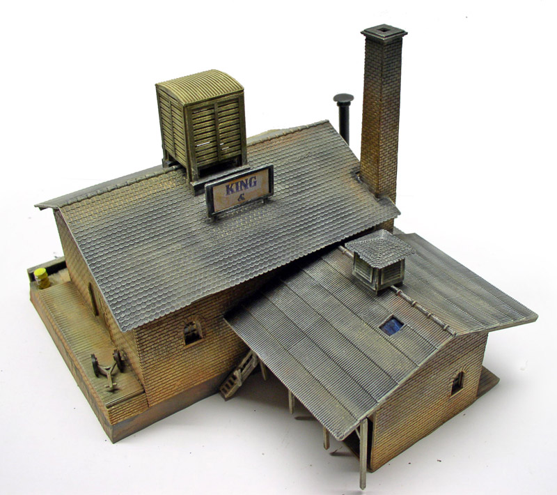 Maquette de bâtiment industriel en brique avec cheminée, toits en tôle et château d'eau