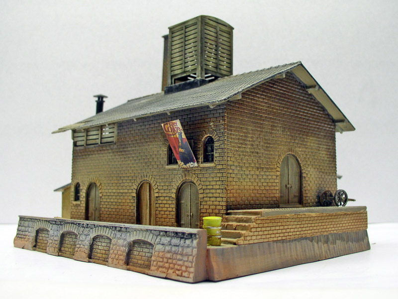 Maquette d'un bâtiment ferroviaire en briques avec château d'eau et muret de soutènement
