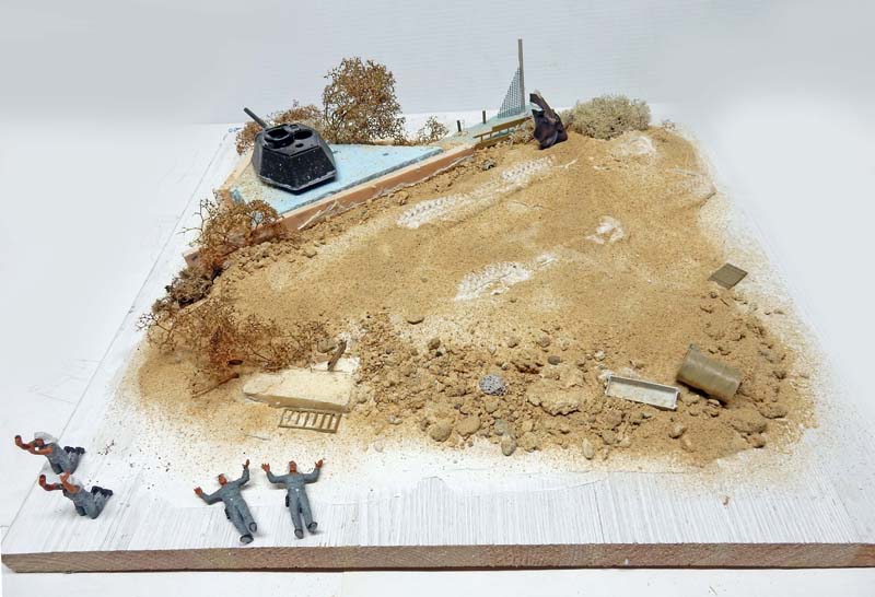 Diorama en cours de montage : plage de sable, tourelle blindée enterrée et figurines