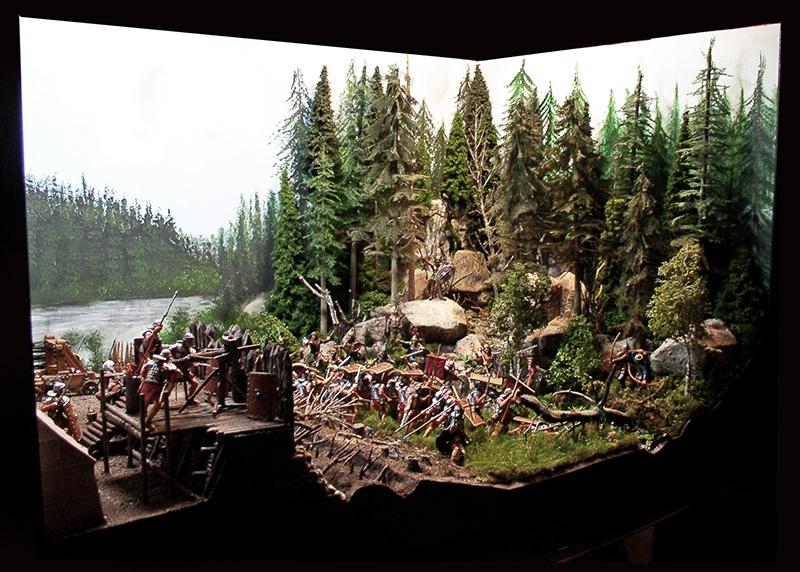 Diorama de soldats romains défendant un fort fortifié dans une forêt de sapins près d'une rivière