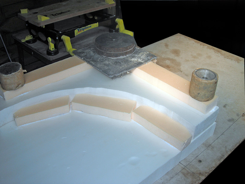 Maquette en polystyrène d'un amphithéâtre romain en construction avec serre-joints et poids