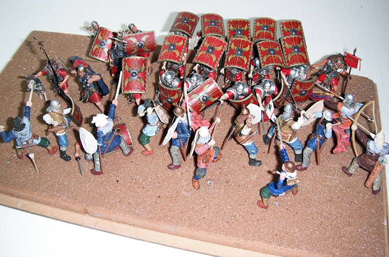 Diorama de figurines de légionnaires romains en formation tortue affrontant des guerriers barbares