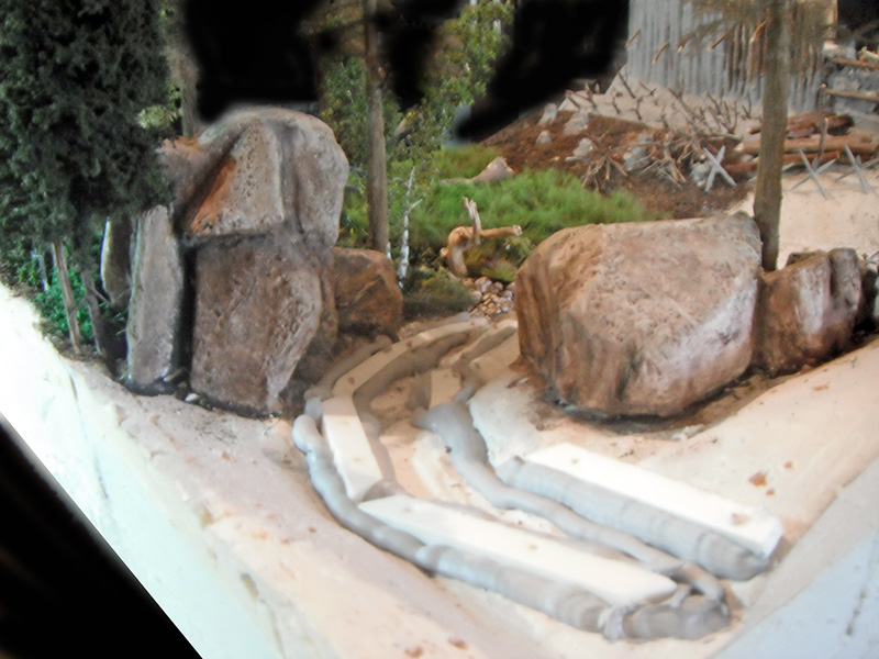 Maquette de camp romain avec gros rochers, chemin sinueux et végétation miniature