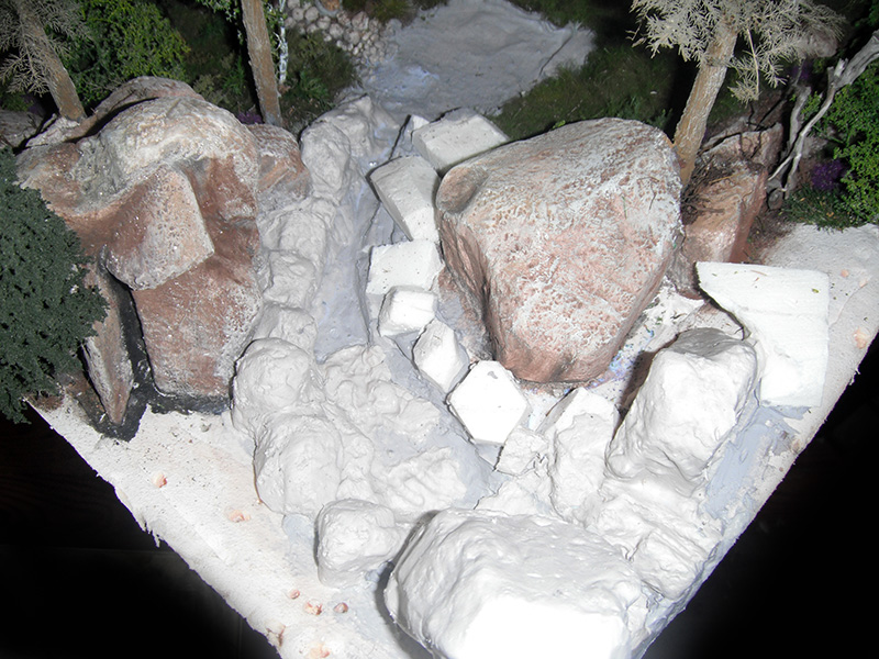 Modelage en cours d'un ravin rocheux en plâtre, rochers et arbres du décor