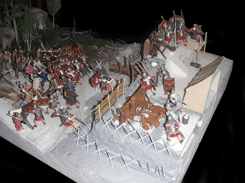 Diorama de figurines de légionnaires romains défendant un camp fortifié assiégé par des Gaulois