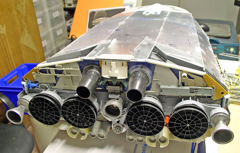 Maquette de cargo spatial vue de l'arrière montrant ses nombreuses tuyères de propulsion sur l'établi