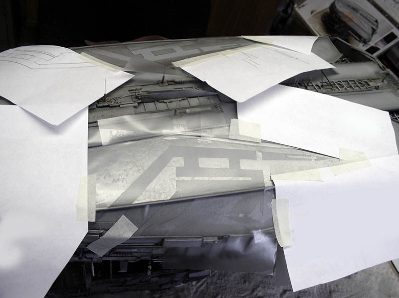 Caches et pochoirs en papier masqués au ruban adhésif sur la maquette du cargo spatial avant peinture