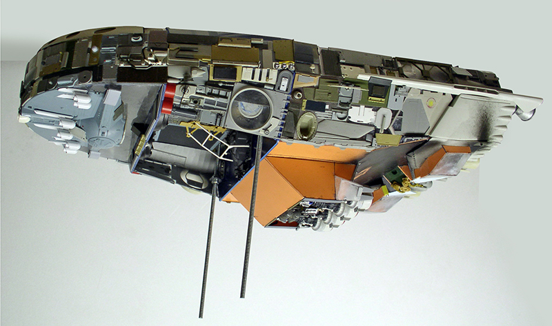 Maquette détaillée de cargo spatial vue de dessous avec coque cuivrée et nombreux éléments mécaniques