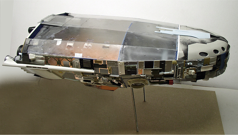 Maquette de cargo spatial vue de profil avec coque détaillée et flanc cuivré