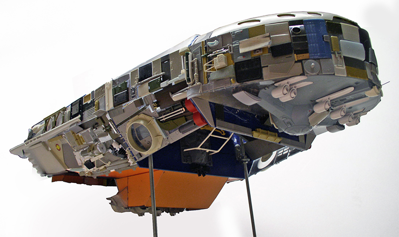 Maquette de cargo spatial détaillée vue de dessous, montée sur supports devant fond clair