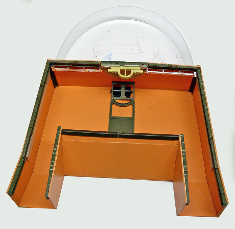 Intérieur orange de la maquette de cargo spatial avec mécanisme de roulettes et structure verte assemblée