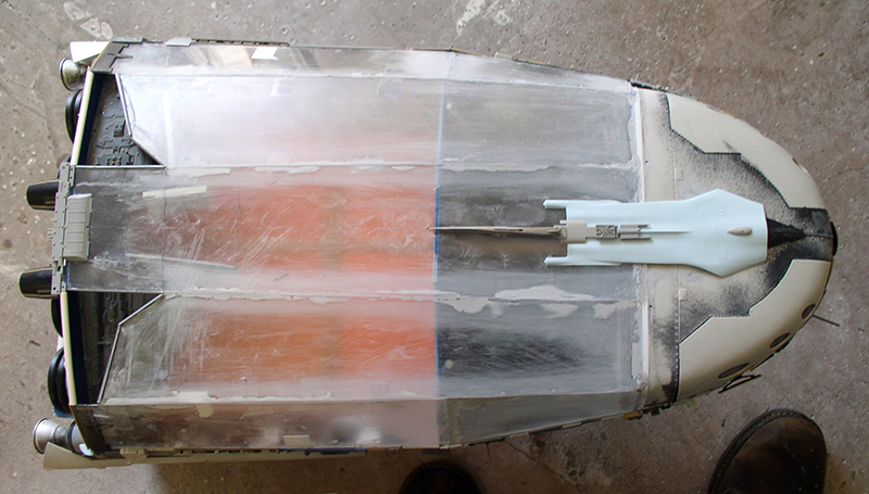 Maquette de cargo spatial vue de dessus avec verrière transparente et coque peinte en cours de construction