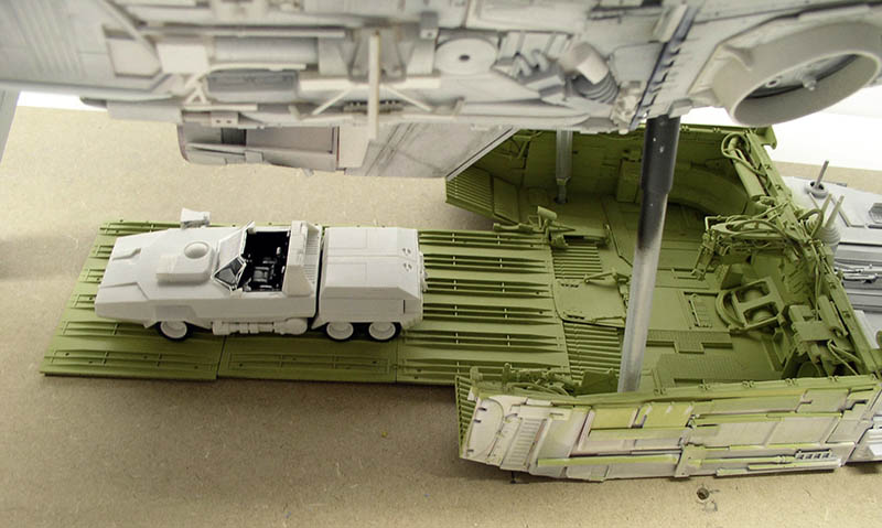 Maquette de cargo spatial vert avec véhicule blanc sur rampe et vaisseau en arrière-plan