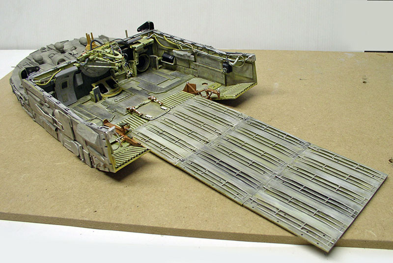 Maquette de cargo spatial vue de dessus avec rampe de chargement dépliée posée sur établi