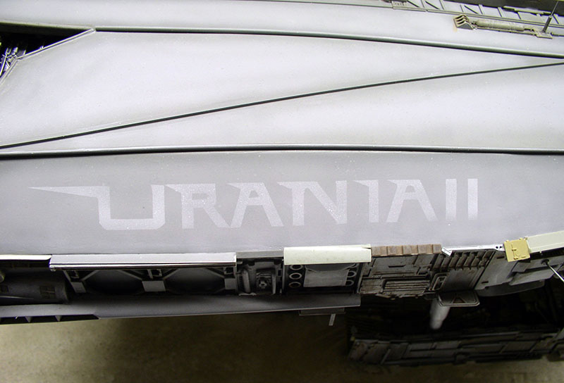 Détail du fuselage gris de la maquette de cargo spatial portant l'inscription Urania II