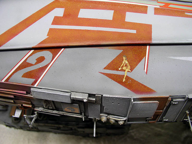 Détail de maquette de cargo spatial gris avec marquages orange, numéro et décalcomanie pin-up