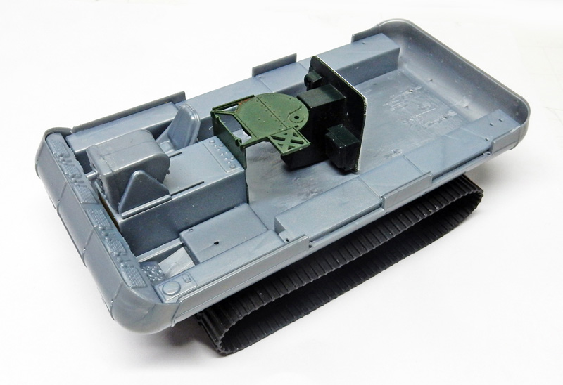 Coque grise de maquette de véhicule chenillé en construction avec siège vert et chenilles
