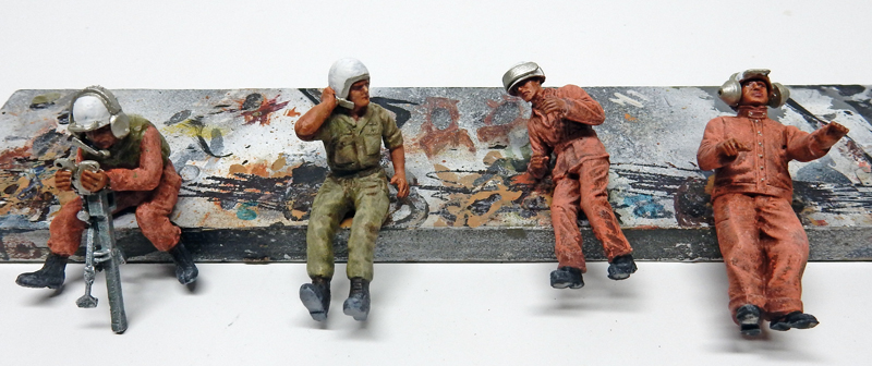 Quatre figurines de pilotes peintes assises sur une poutre patinée pour diorama de maquettisme