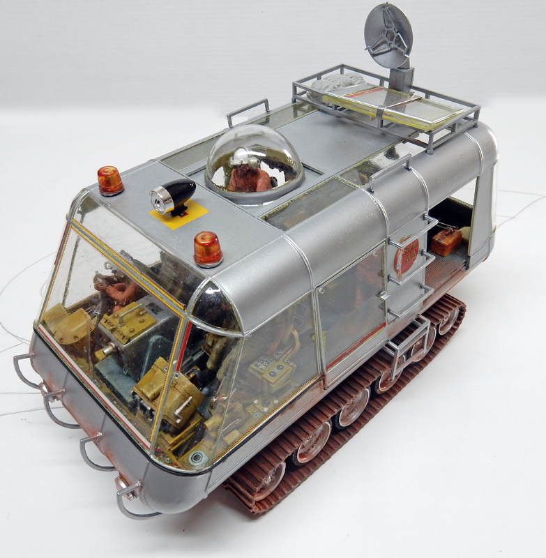 Maquette de véhicule chenillé argenté avec dôme transparent, gyrophares et antenne sur le toit