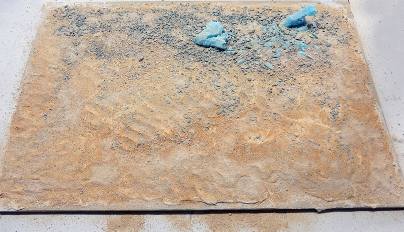 Socle de diorama en préparation avec sable, gravier et morceaux de mousse bleue