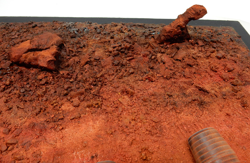 Socle de diorama recouvert de terre rouge et de gravats avec rochers ocres
