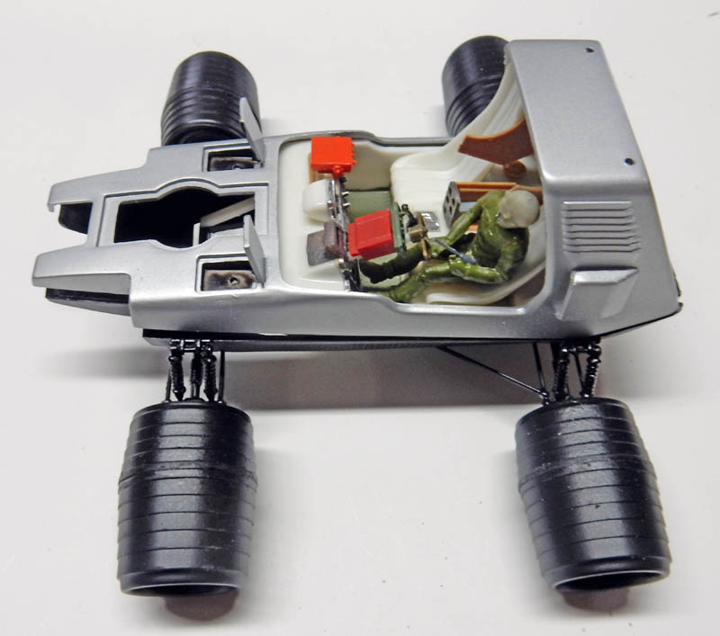 Maquette de véhicule lunaire argenté avec cockpit ouvert, figurine d'astronaute vert et gros pneus
