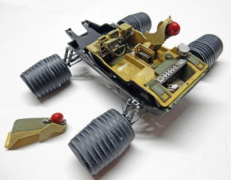 Maquette de rover lunaire en cours d'assemblage avec roues détaillées et siège