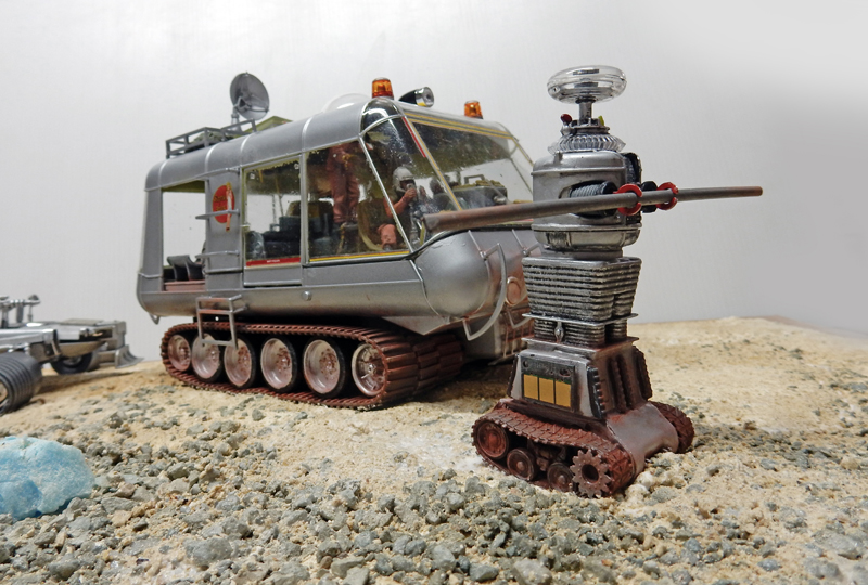 Diorama maquette du chariot chenillé argenté et du robot à côté sur sol rocheux